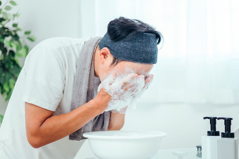 皮脂を落とそうと躍起になって洗顔する男性。こうした「ゴシゴシ洗い」こそが、必要な潤いまで奪いインナードライをさらに悪化させるNG習慣であることを警告するイメージ。